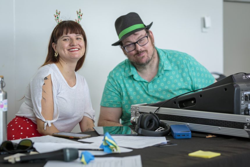 A picture of Luz and Matthew sitting next to his sound equipment ready to start the disco. 